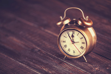 Retro alarm clock on a table. Photo in retro color image style