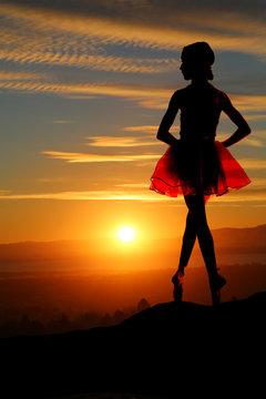 Young ballerina on a mountain overlooking a beautiful sunset