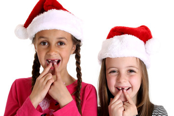 girls wearing santa hats missing their two front teeth