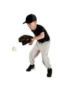 Young caucasian baseball player backhanding a ground ball