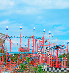 red roller coaster under a blue sky