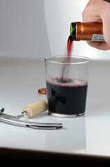 Rotwein in Glas eingießen