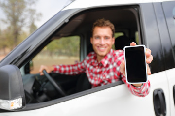 Smart phone man in car driving showing smartphone