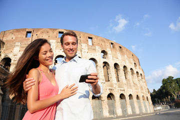 Couple in Rome by Colosseum using smart phone