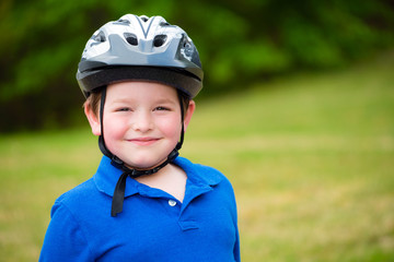 Happy child wearing a bike helmet outdoors