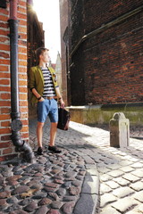 Young man with bag on street, old town Gdansk