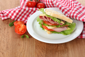 Tasty sandwich with ham on wooden table