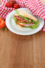 Tasty sandwich with ham on wooden table