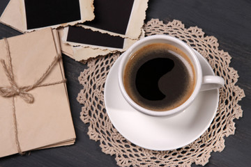 Coffee cup and old blank photos, on wooden background