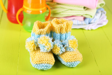 Composition with crocheted booties for baby,clothes, bottles