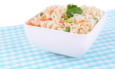 Tasty instant noodles with vegetables in bowl on table close-up