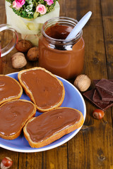 Bread with sweet chocolate hazelnut spread on plate on table