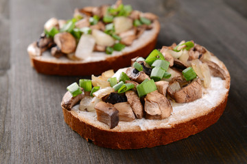 Delicious bruschetta with mushrooms on table close-up