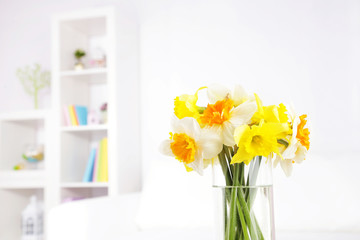 Beautiful spring flowers in vase on home interior background