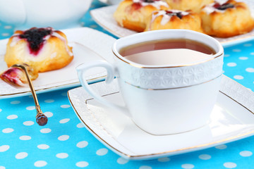 Cup of tea with sweet pastries on table close-up