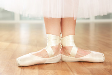 Ballerina legs in pointes in dancing hall © Africa Studio