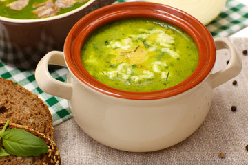 Tasty soup in saucepan on tablecloth, close up