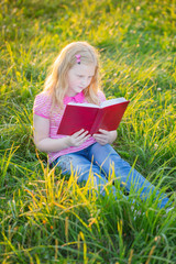 Naklejka na ściany i meble little blond girl reading red book