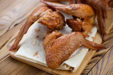 Close-up of smoked chicken wings on pita bread, studio shot
