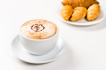 large cup of coffee and croissants on a plate