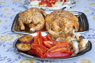 Two chicken roasted on grill with garnish