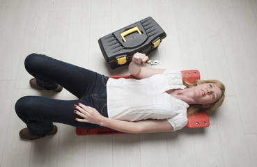 Mechanic with spanner laying on a crawler