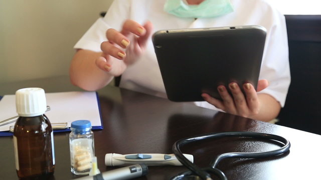 Female doctor working with digital tablet in office