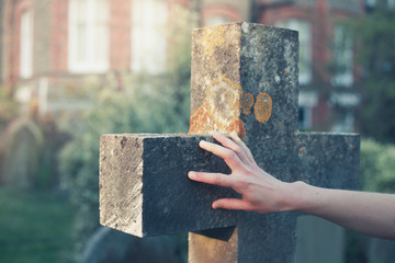 Hand touching a gravestone