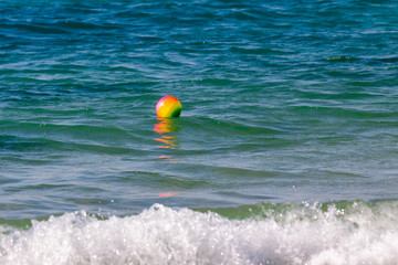 A bright colorful ball on waves in Mediterranean Sea
