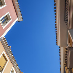 Spanish apartments, pastel colours and balconies against blue s