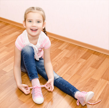 Cute Smiling Little Girl Tying Her Shoes