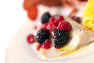 Macro close up of grilled sea with berry and potatoes