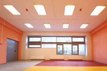Empty gym with orange walls and windows in kindergarten