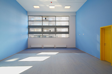 Group room with blue walls and windows in kindergarten