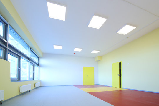 The playroom with yellow walls and windows in kindergarten