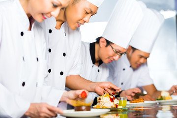 Asian Chefs in restaurant kitchen cooking