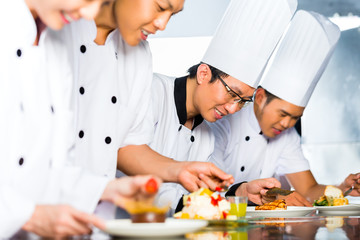 Fototapeta na wymiar Asian Chefs in restaurant kitchen cooking
