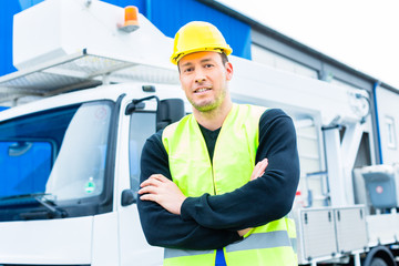 Kranfahrer vor Kranwagen einer Baustelle