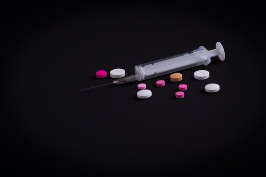 dark table, pills and injection