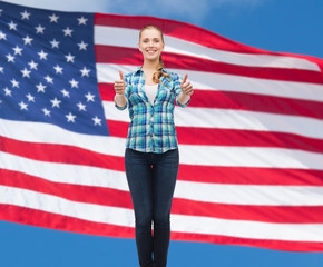 young woman in casual clothes showing thumbs up