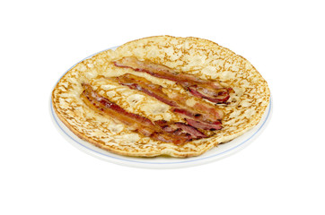 A plate with a pancake with bacon strips on a white background.