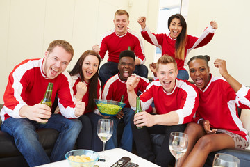 Group Of Sports Fans Watching Game On TV At Home