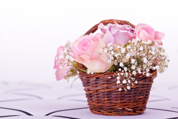 pink roses in brown basket of withe background