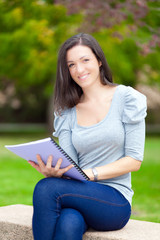 Obraz premium Young beautiful female student reading a book