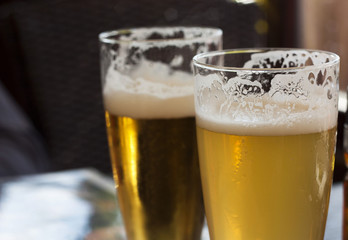 Two glasses of beer in bar.