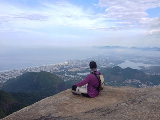Fototapeta na wymiar Man sitting on edge of mountain, Rio de Janeiro