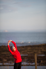 Young woman on her evening jog along the seacoast © lightpoet