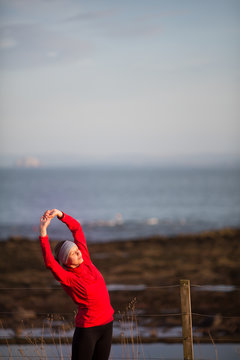 Young woman on her evening jog along the seacoast