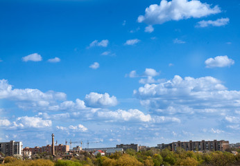 blue sky with field of green grass and city on the horizon