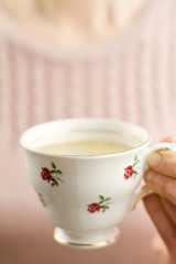 Woman holding china teacup of tea
